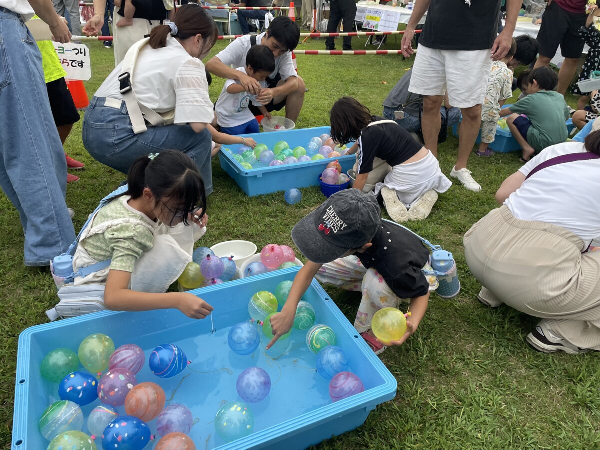 芝生広場でスーパーボールすくいを楽しむ親子