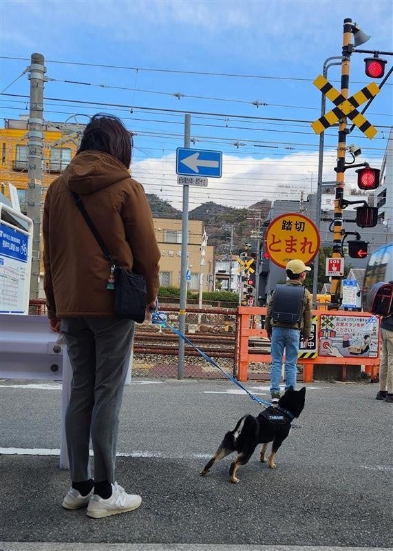踏切で愛犬と通学中の子どもを見守る隊員