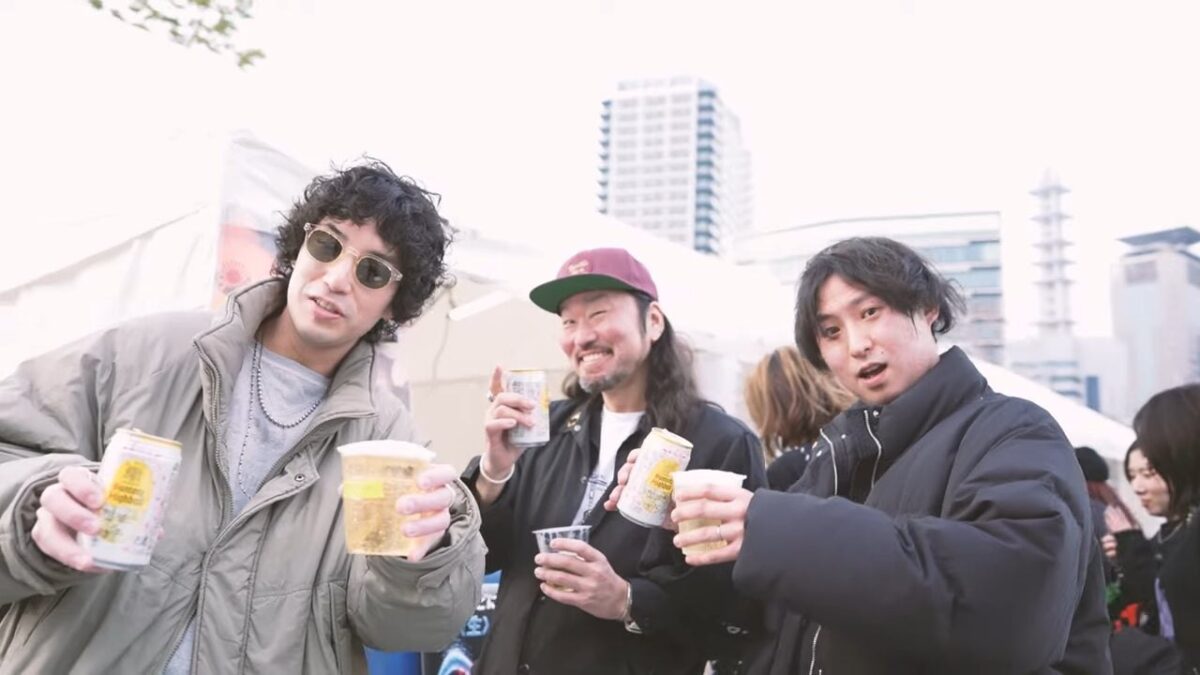 屋外の飲食ブースでドリンクを楽しむ来場者