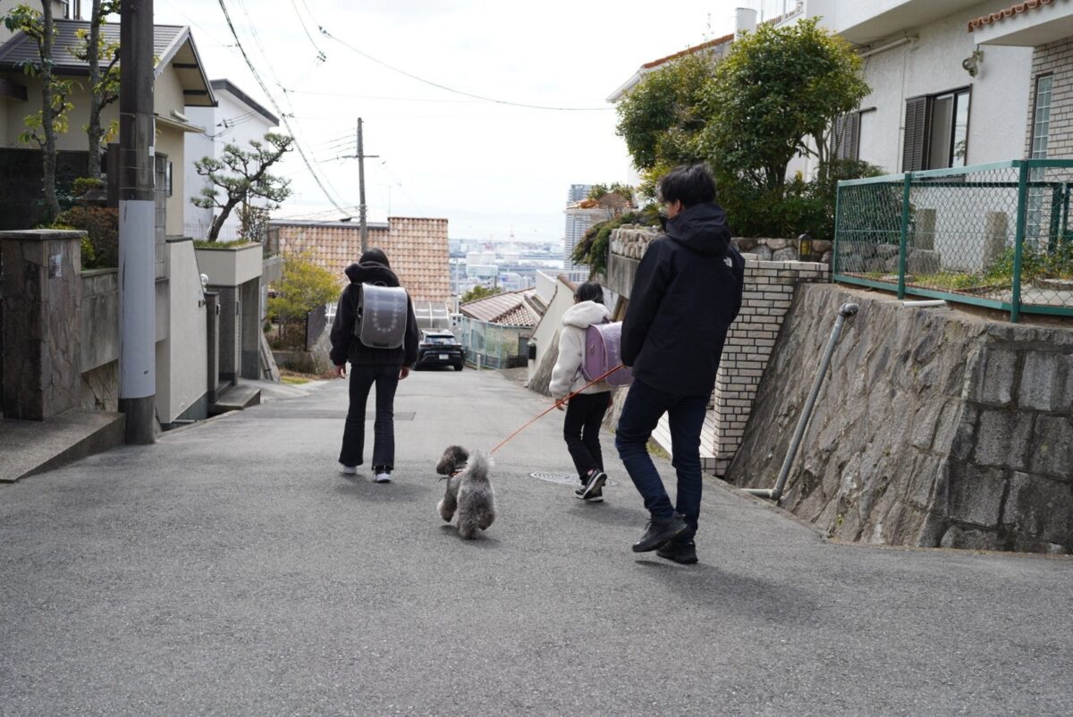 犬の散歩で子どもたちの通学路を見守る様子