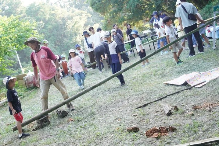 はたびーで竹を運ぶ子どもと大人