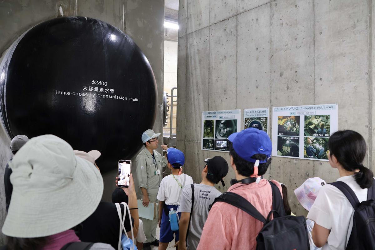 立坑の地下で大容量送水管の先端部を見学する様子