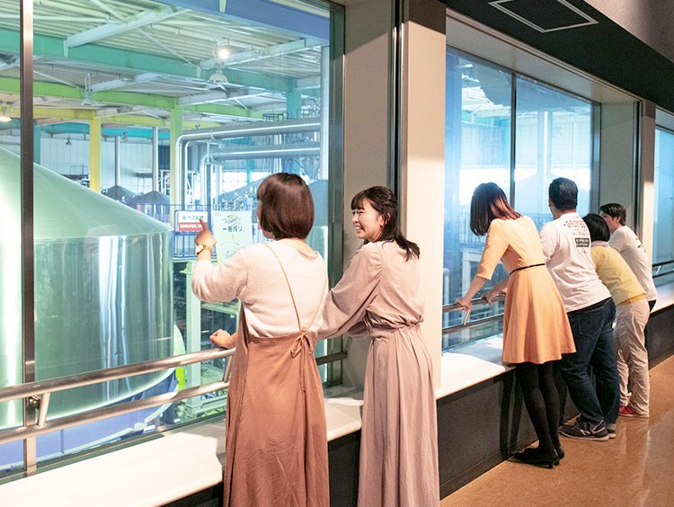 ガラス越しに仕込釜を見学するツアー参加者