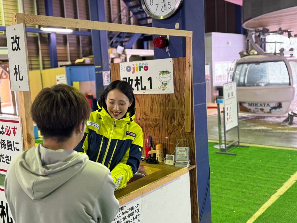 スキー場の改札でスタッフにリフト券を提示する来場者