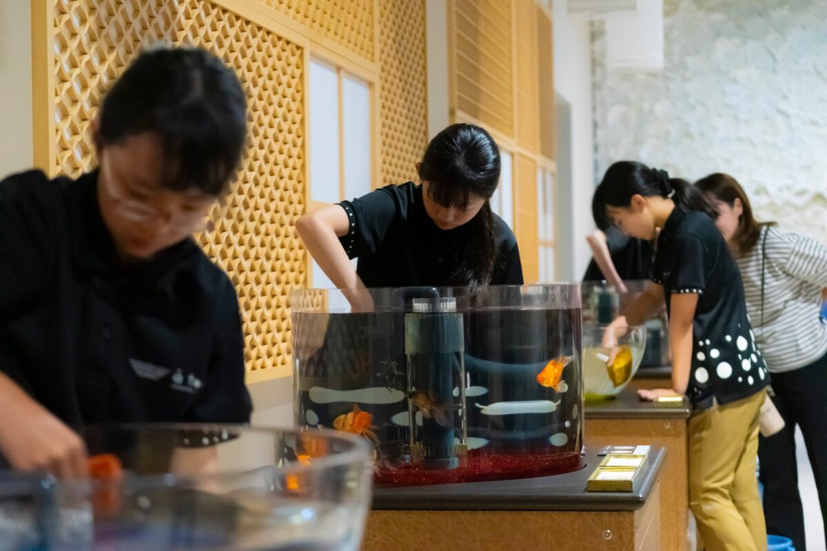 金魚の水槽を手入れするスタッフ