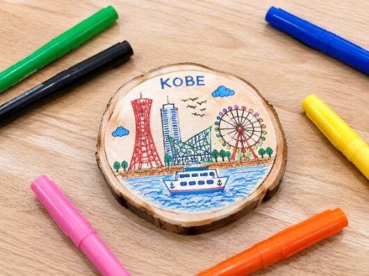 神戸の街並みを描いた木製のオリジナルコースター