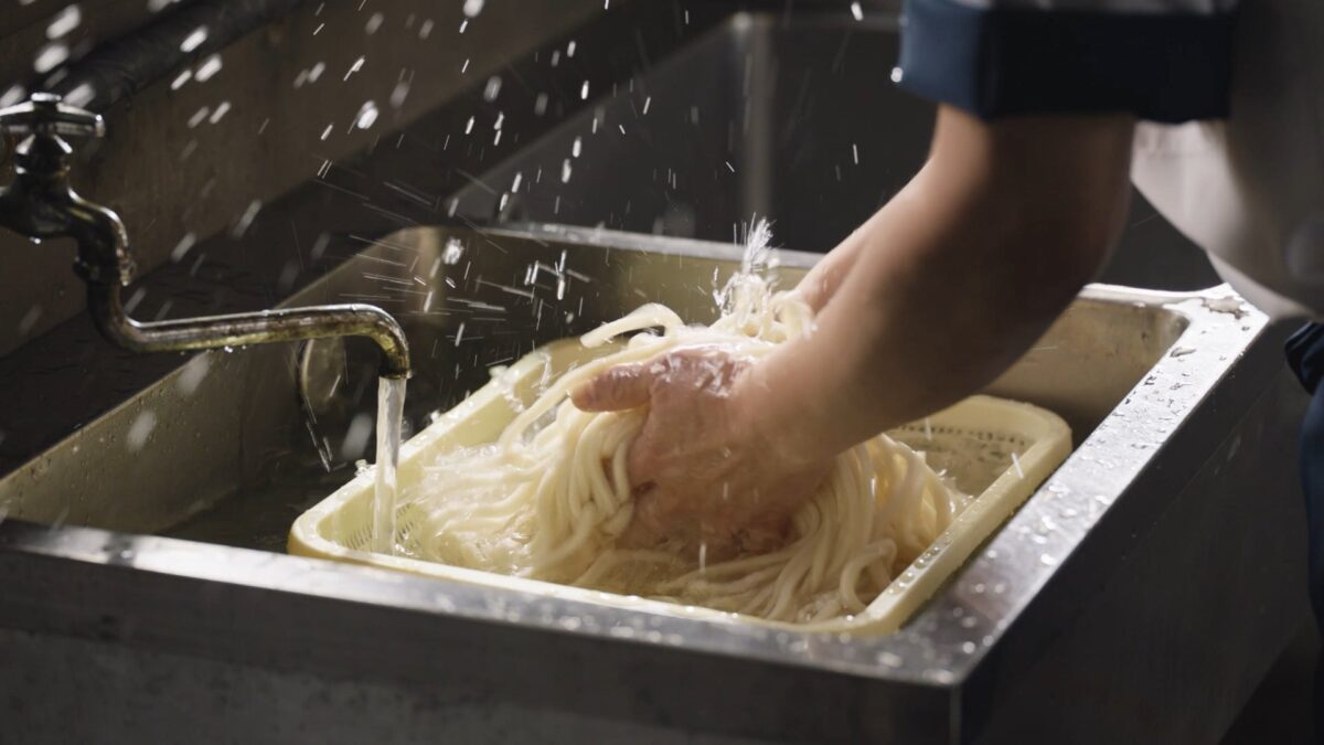 茹で上がった麺を冷水で締める作業