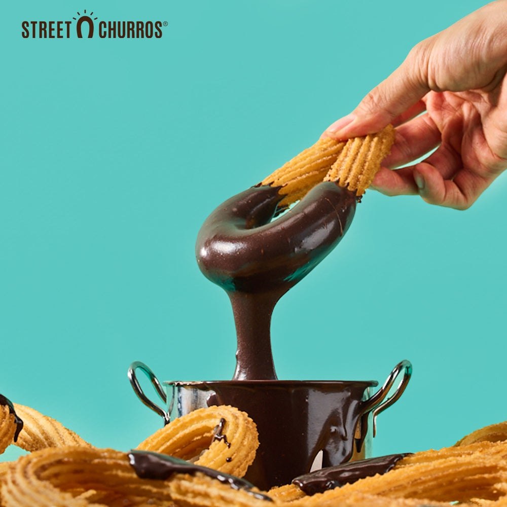 チョコレートソースにディップしたSTREET CHURROSのチュロス