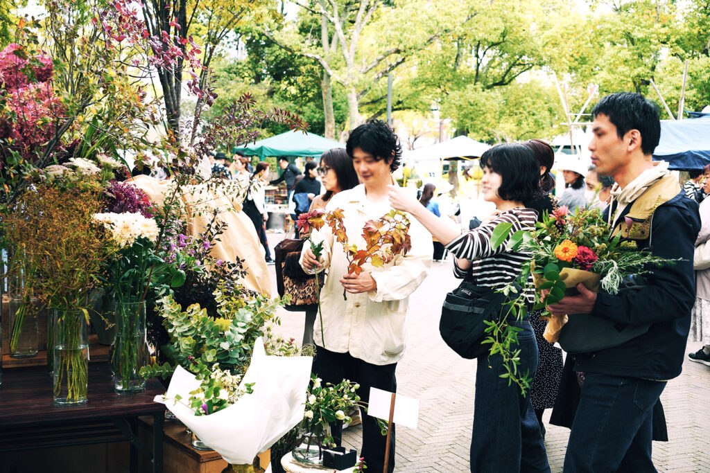 花や枝ものを手にする来場者