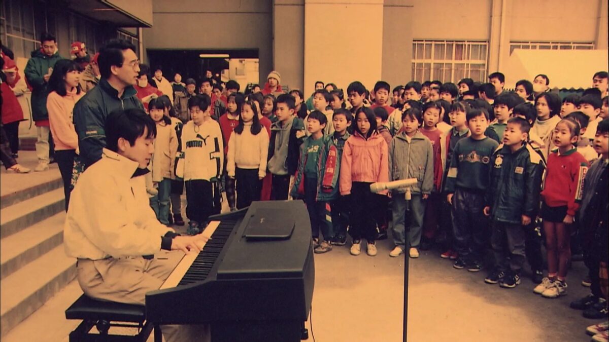 ピアノを囲んで歌う子どもたち
