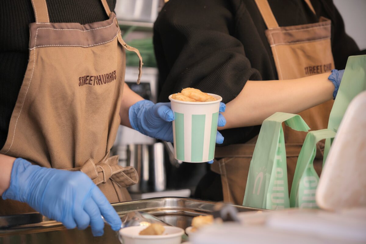 カップに入ったチュロスを手渡すSTREET CHURROSのスタッフ